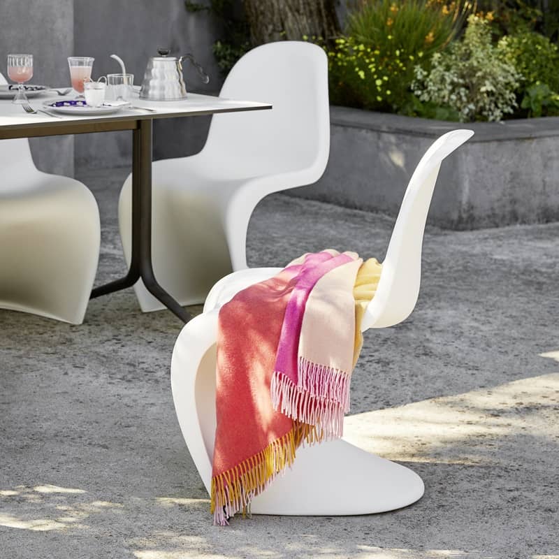 &Uuml;ber dem Stuhlklassiker Panton Chair liegt eine farbige Wolldecke
